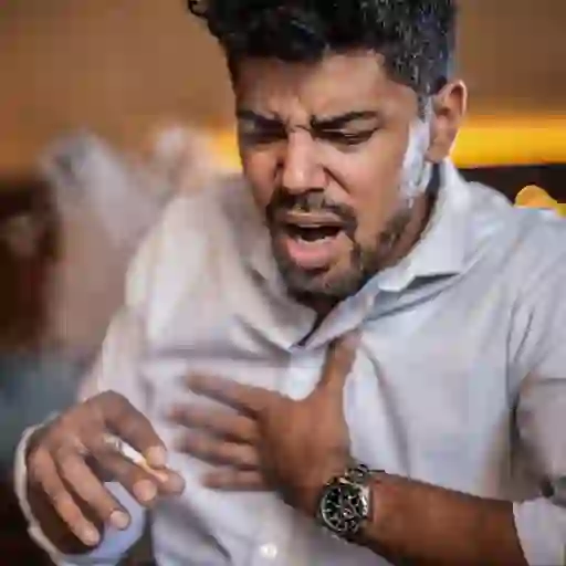 一个男人一边抽烟一边咳嗽