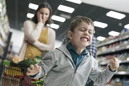 Child with dysmorphic mood dysregulation disorder having an outburst in a supermarket.