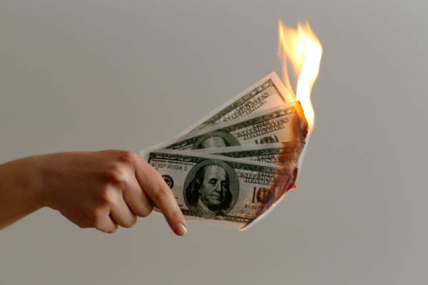 手握着100美元的钞票着火了