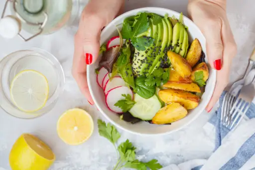 绿色健康素食主义者早餐沙拉用被烘烤的土豆，鲕梨和萝卜。