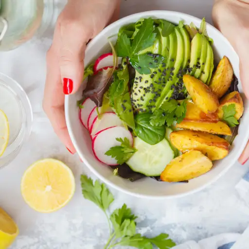 绿色健康素食主义者早餐沙拉用被烘烤的土豆，鲕梨和萝卜。