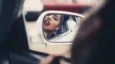 女人穿上口红在汽车后视镜