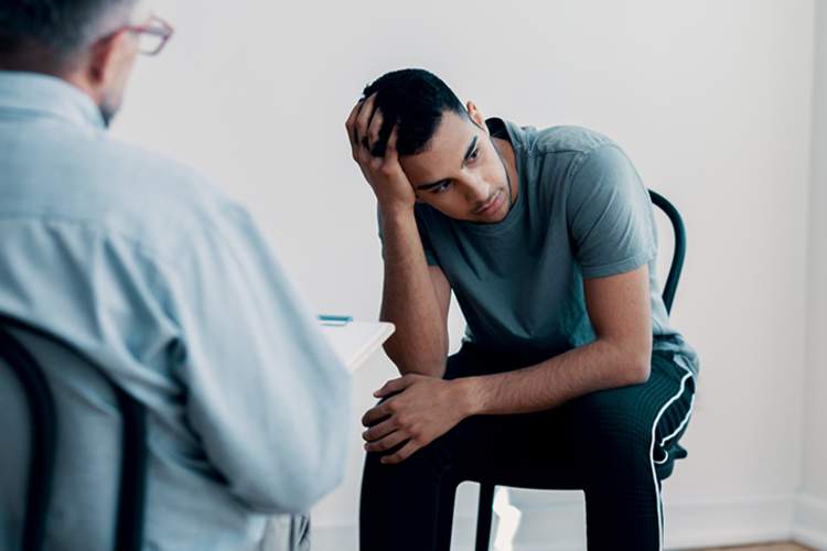 男人感到压力，同时听着精神保健专业人士。