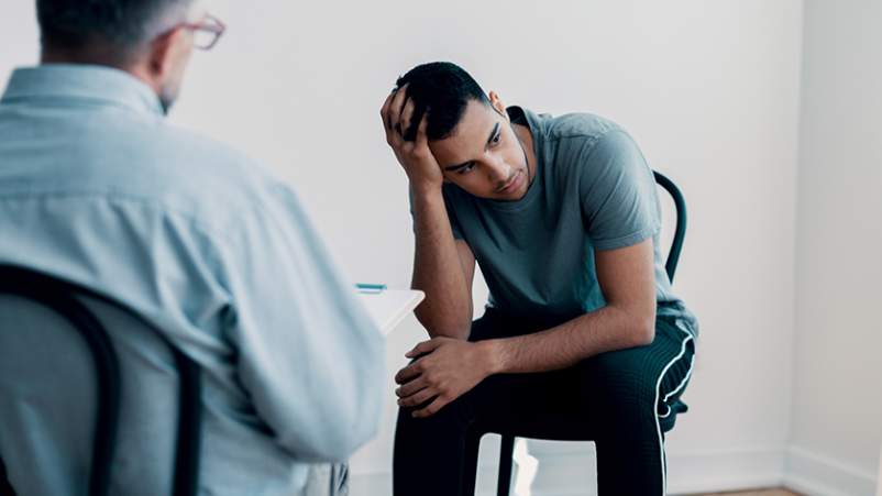 一名男子在听心理健康专家倾诉时感到有压力。