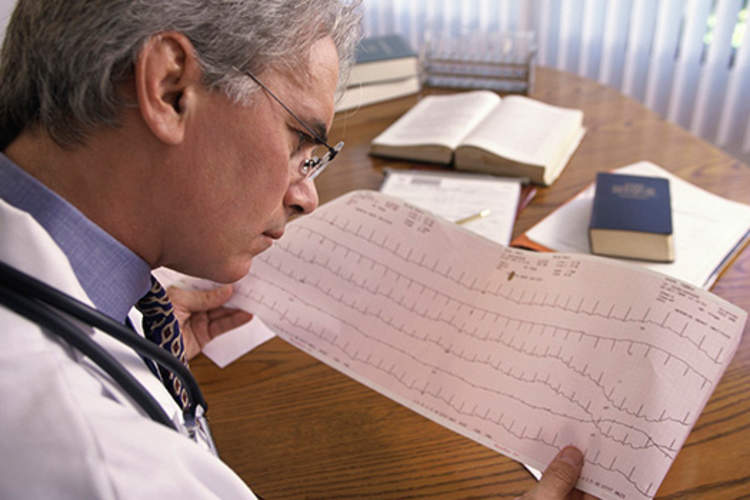 医生看着心电图打印输出