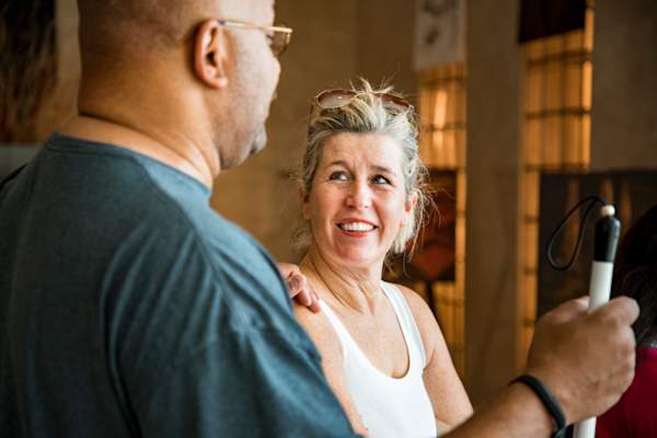 成熟的白人妇女站在旁边,一个成熟的非洲裔美国人谁是视障