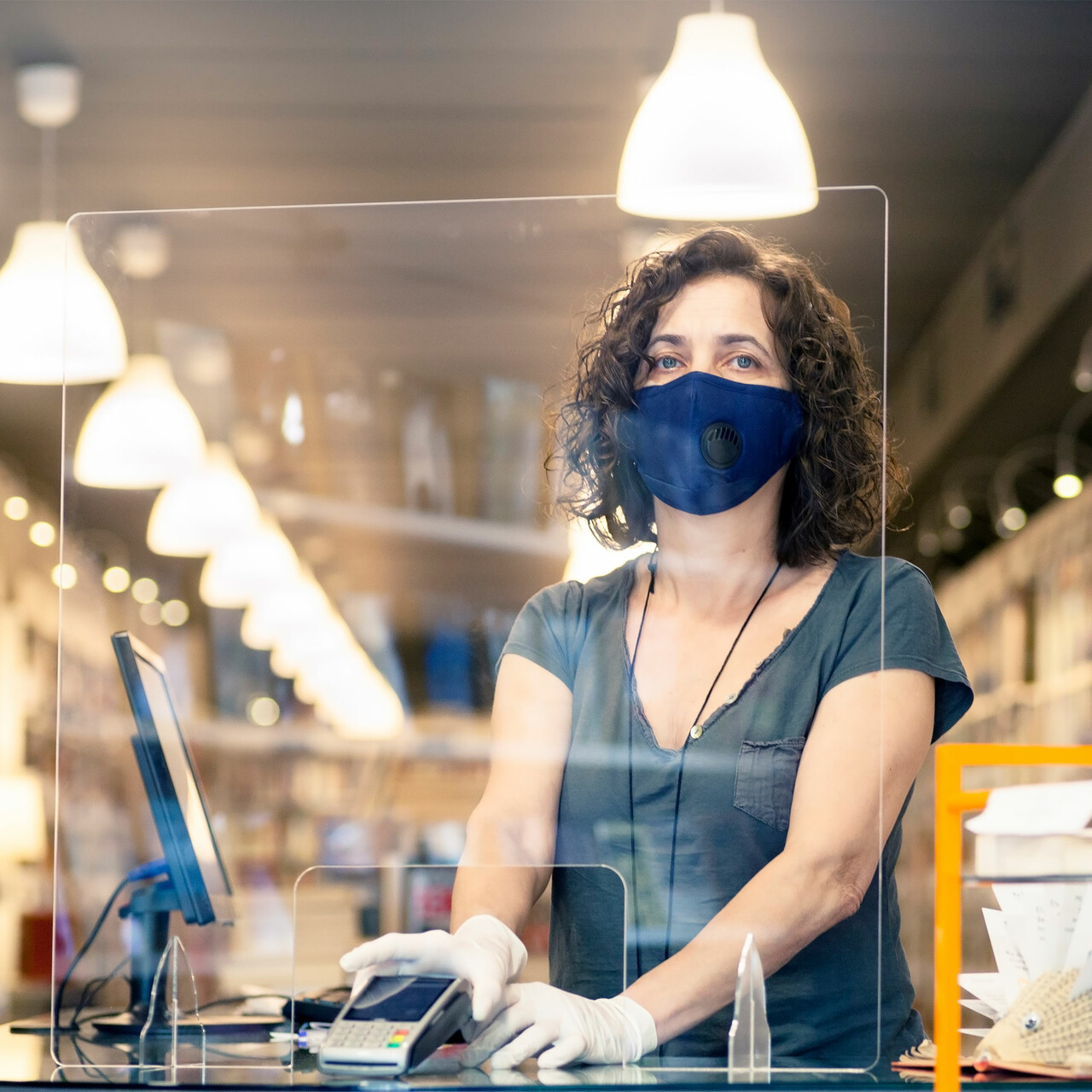 一个收银员站在隔板后面