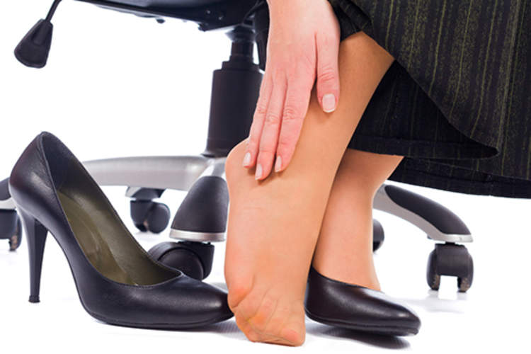 女子足部疼痛在工作中,鞋子掉,搓脚。