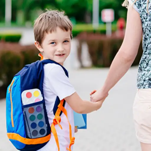 背着背包和妈妈一起上学的孩子。