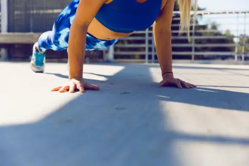 穿蓝色运动胸罩做俯卧撑的女人
