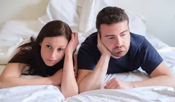 一对年轻夫妇焦急地躺在床上。
