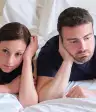 一对年轻夫妇焦急地躺在床上。