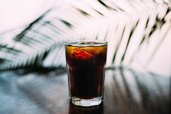 soda in glass in front of leaves