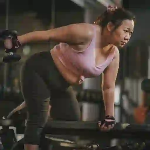在健身房举重的女人。