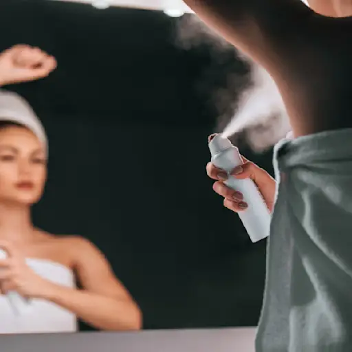 毛巾的妇女喷洒在除臭剂