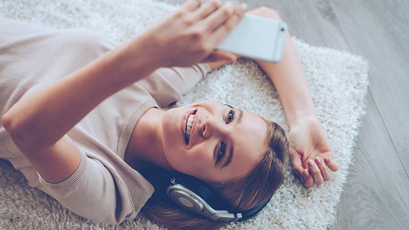 躺下的妇女使用她的手机。