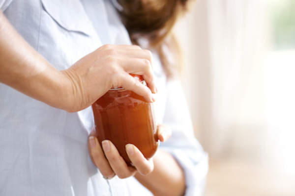 女子试图打开罐子。