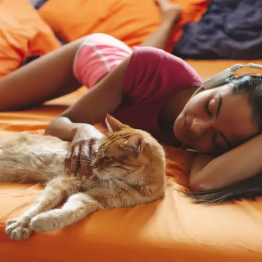女人带着猫躺在床上听耳机