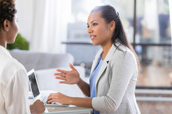 医生在笔记本电脑上和病人交谈。