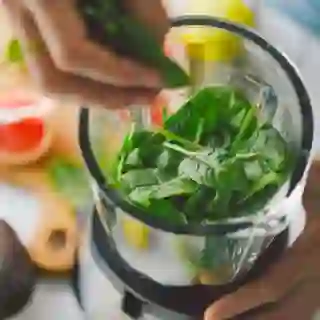 Fruits and vegetables being put in a blender