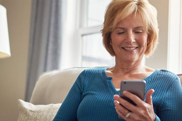 中年妇女使用智能手机应用程序。