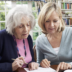 女人帮年迈的母亲与财政图像。