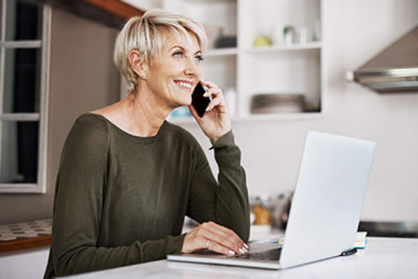 女子在电话交谈,而用她的笔记本电脑。