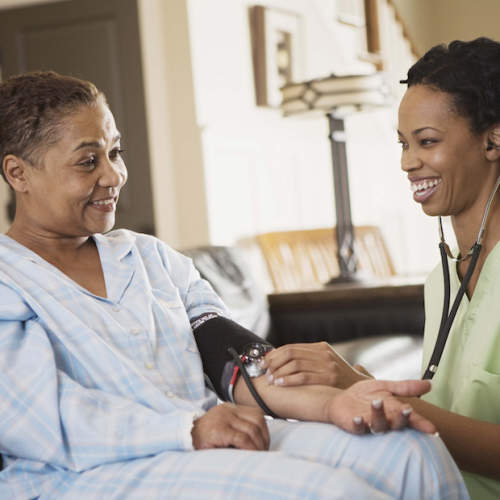 一位护士为一位老年妇女量血压。