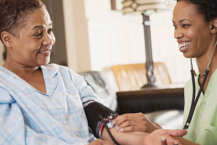 一位护士为一位老年妇女量血压。