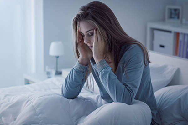 失眠女子坐在了床上,而在痛苦中。