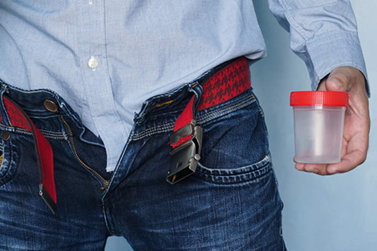 一名男子拿着一个空罐子进行精子分析。