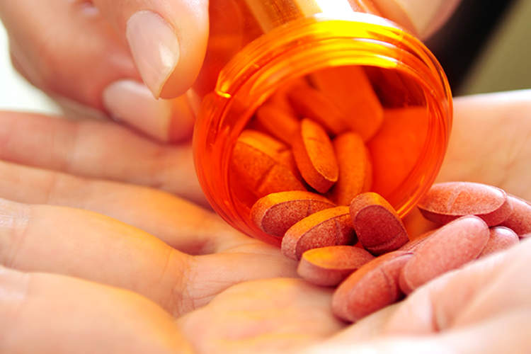 一个女人把药丸倒在手上。