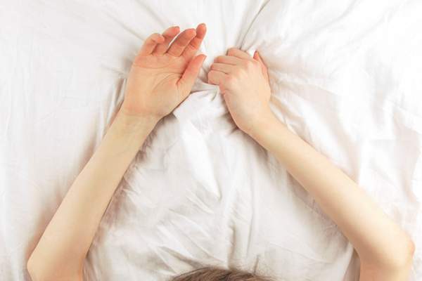 女人的手抓着床单