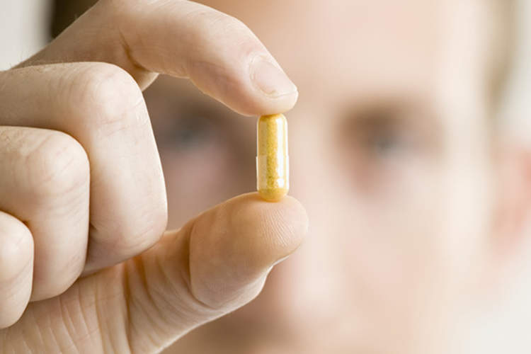 男子拿着起来黄色药丸