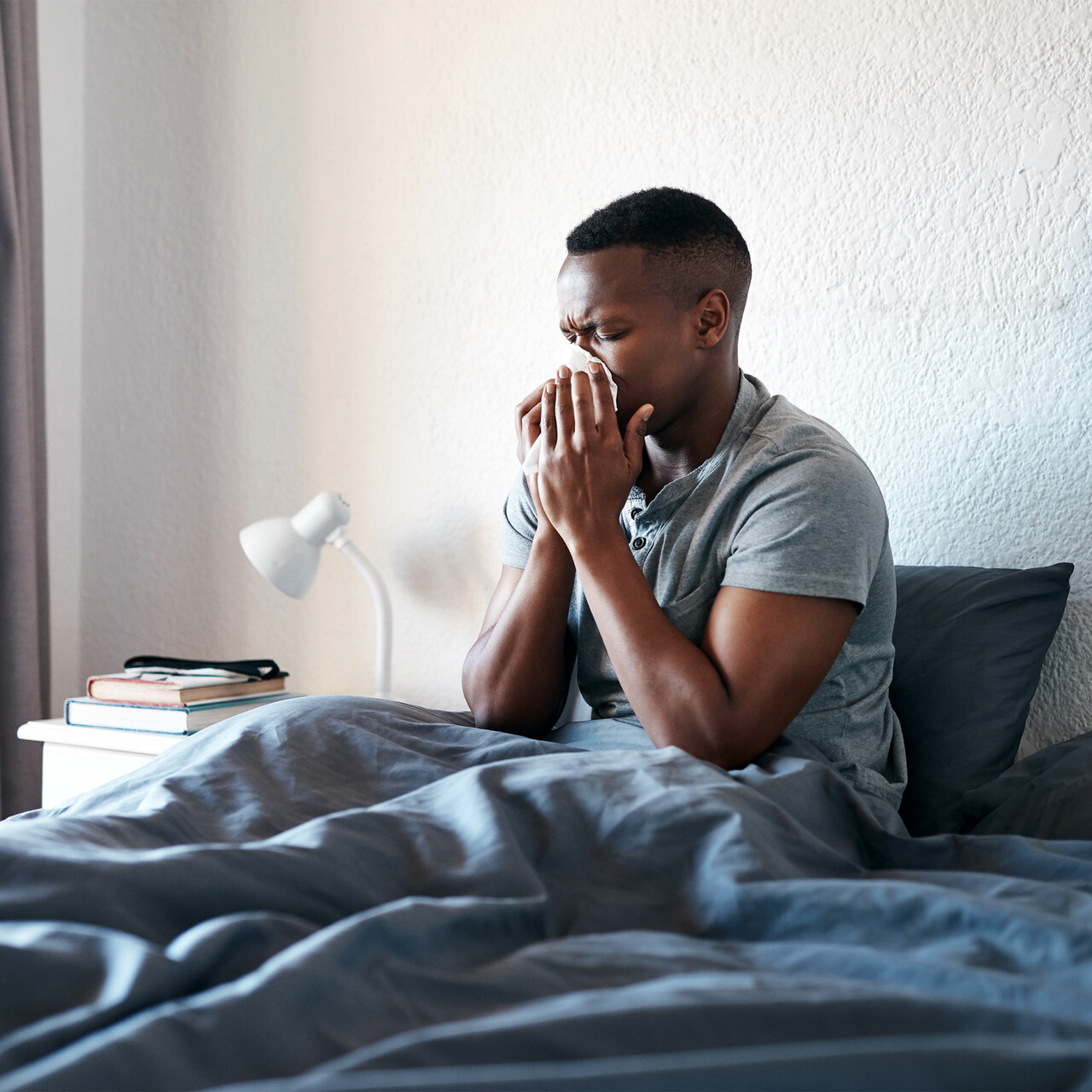 一个病人在床上吹他的鼻子