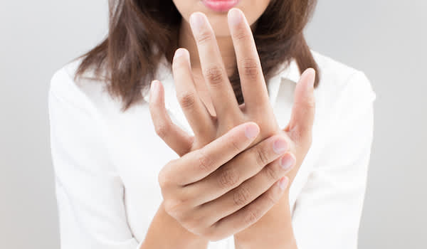 Woman trying to rub numbness out of hand.