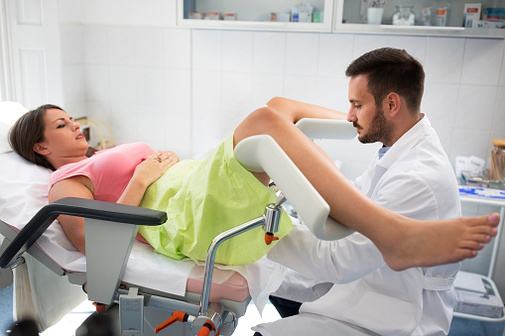 女人IUD插入接收骨盆检查从妇科医生之前。