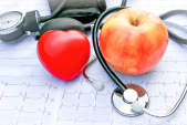 桌上有一个苹果，一个心脏和一个听诊器。