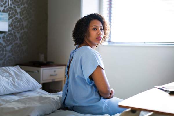 年轻女子在医院的病床上坐起来