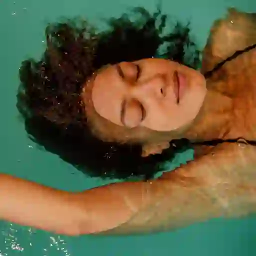 女子放松漂浮在游泳池。