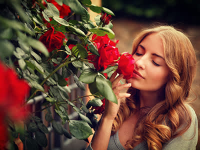 女子闻玫瑰。