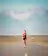 一个女人在沙漠中奔跑，背景是群山