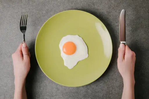 在板材的唯一鸡蛋，拿着刀子和叉子的手，但不吃