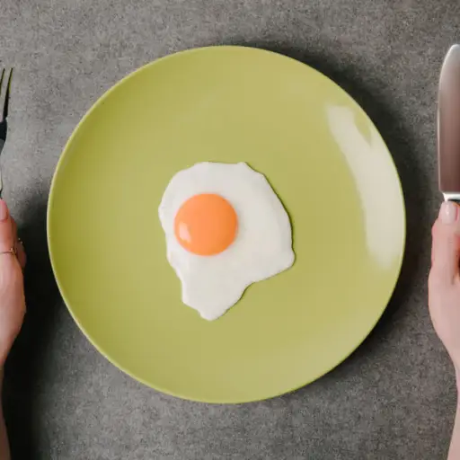 一个鸡蛋放在盘子里，手拿刀叉但不吃
