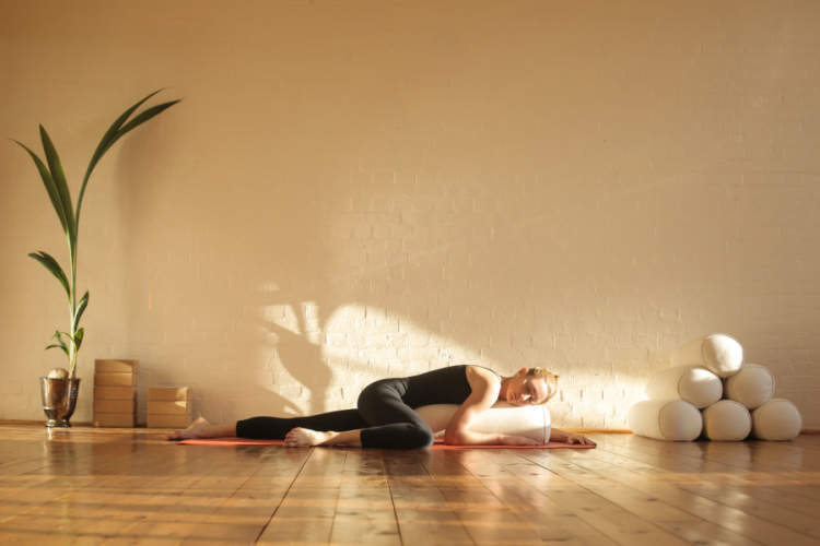 一名女子在一间漂亮的工作室里练习恢复性瑜伽