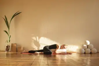 一个在美丽的工作室练习恢复性瑜伽的女人
