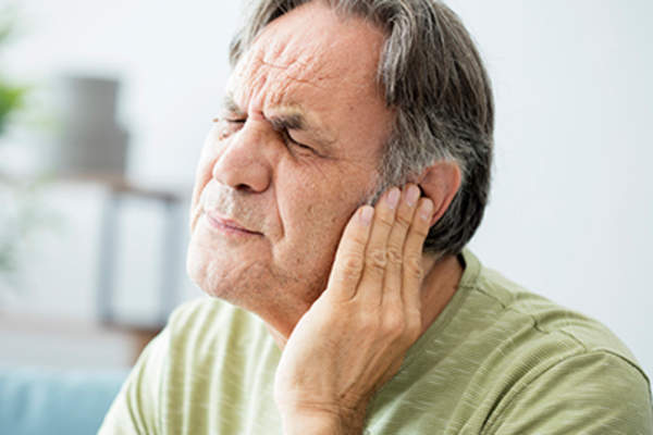 耳朵痛的男人抱着他的耳朵。