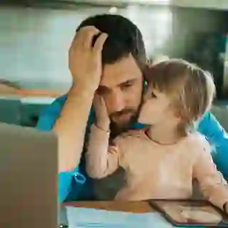Depressed man holding young daughter who is comforting him.