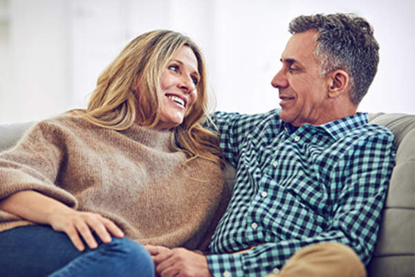 在家里的沙发上交谈成熟的情侣。