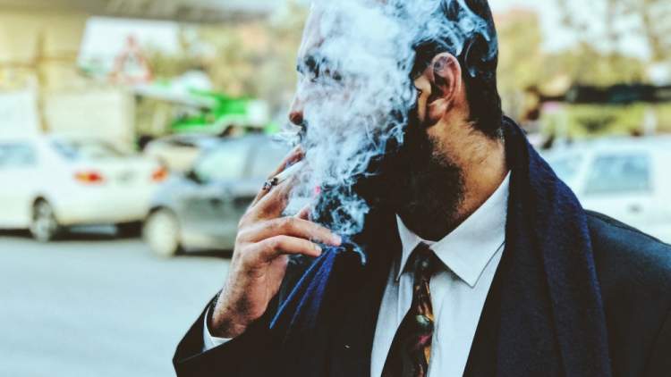男子吸烟香烟 - 脸上布满烟雾